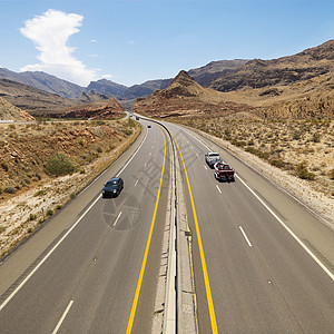 双向四车道沙漠高速公路上的汽车背景
