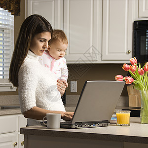 母亲与婴儿电脑互联网女孩妈妈笔记本父母女婴女性家庭通信图片
