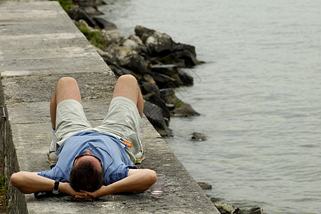 躺在湖边孤独酒杯海堤岩石玻璃睡眠拉伸支撑图片