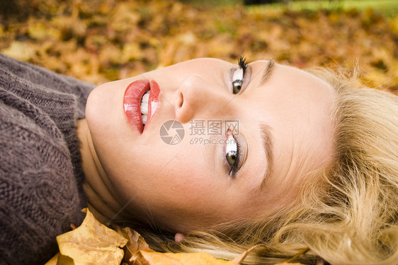秋叶中的女孩化妆品树叶橙子头发叶子青年金发女郎女性女士阳光图片