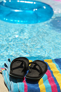 蓝泳池假期椅子阳光水池旅行季节凉鞋晴天游泳毛巾图片