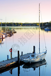 日出时游艇木头航行风景反射海洋流浪帆船码头半岛桅杆图片
