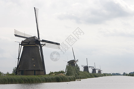 排成一行的荷兰风车小孩旅行农业旅游堤防背景图片