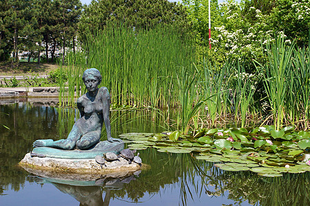 荷花雕塑妇 女芦苇地荷花雕像雕塑旅游公园盛会植物群阳光绿色背景