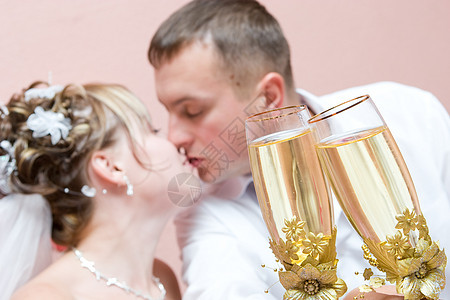 新婚夫妇亲吻 满杯香槟的一对新婚夫妇图片