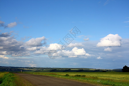 田野中的公路蓝天天空背景图片