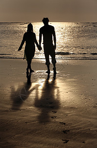 日落时对夫妇幸福夫妻享受情感海岸环境假期友谊旅行海滩图片