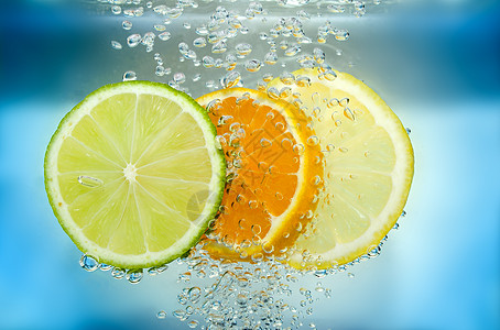 水中的柑橘片空气蓝色苏打活力绿色食物黄色液体宏观水果背景图片