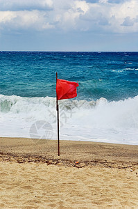 飘扬的红旗红旗安全蓝色波浪警报海滩危险天空多云红色旗帜背景