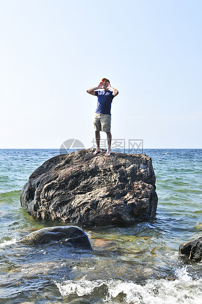 人类被困在海洋中的岩石上海难概念孤独石头男性流浪灾难成人呼唤巨石图片