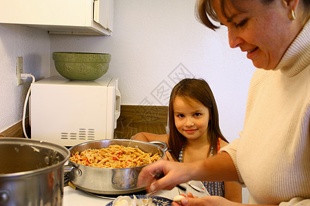 帮助妈妈做饭的小女孩学习面包师孩子们青年闲暇母亲厨师女性父母孩子图片