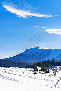 雪上山顶的孤单木屋图片