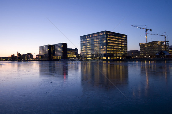 哥本哈根港城市冷冻建筑办公室蓝色起重机反射日落运河图片
