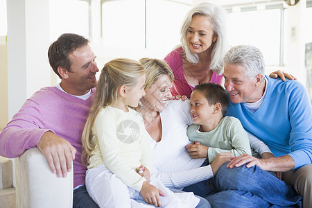 家庭坐在室内微笑的笑容女孩婴儿潮亲密感女儿客厅女性儿子团体沙发孙子图片