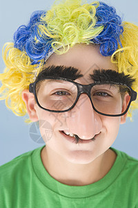 年轻男孩戴小丑假假假发 假鼻子微笑影棚孩子孩子们乐趣小男孩男生情感戏服眼镜享受图片