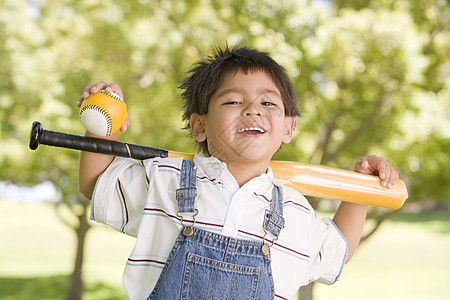 年轻男孩拿着棒球棒在户外微笑小男孩运动公园拉丁花园孩子男性男生水平视图图片
