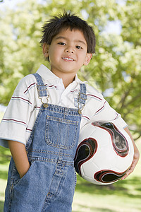 在户外微笑着拿着足球球的年轻男孩孩子花园女性公园男生玩家情感小男孩享受拉丁图片