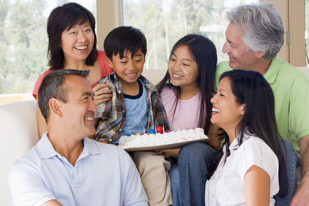 家庭在客厅 蛋糕微笑女士孩子们生日父亲儿子退休蜡烛男性孙辈孩子图片