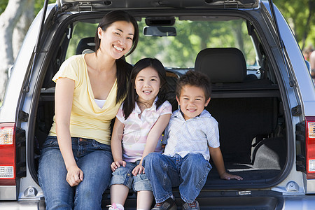 有两个孩子的女人坐在面包车后面微笑着笑着父母家庭姐姐兄弟儿子相机女儿农村商务车妈妈图片