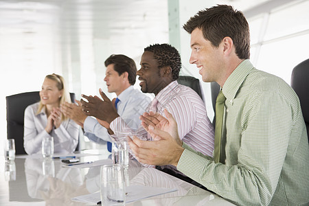 一个会议室的四位商务人士 鼓掌鼓掌四个人中年男人讨论公司生意人会议桌董事会同事商务图片