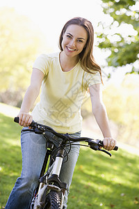 骑自行车微笑的妇女农村踪迹女性公园享受山地世代骑术图片