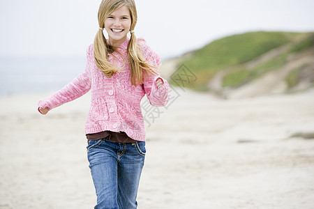 年轻女孩在海滩上微笑着笑笑的奔跑图片