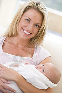 母亲在起居室 婴儿微笑妈妈客厅两个人拥抱沙发女儿家长女士新生孩子图片
