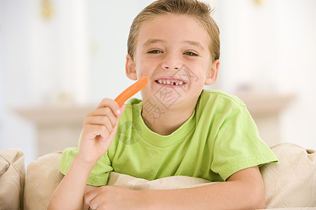 小男孩在客厅里吃胡萝卜棒 微笑着笑着图片
