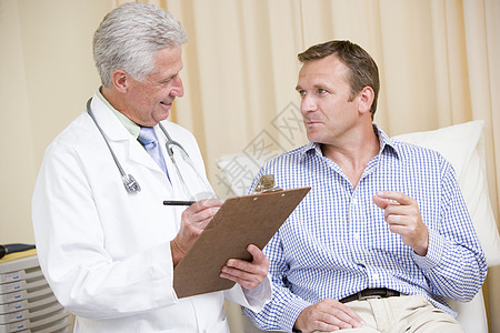 医生在剪贴板上写作 同时给男人检查胸腺医师女性顾问大衣中年男性外科疾病诊所考试图片