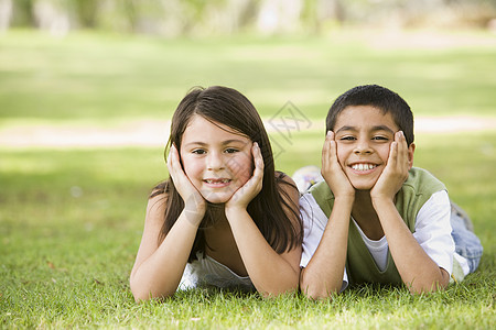 坐在公园里笑着躺着的两名儿童户外男性孩子女孩女性焦距阶段兄弟水平家庭幸福图片
