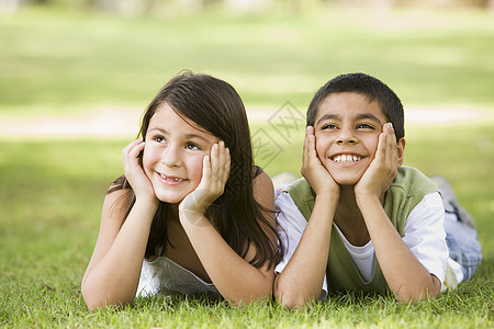坐在公园里笑着躺着的两名儿童户外家庭男孩闲暇女孩阶段水平小学孩子情感年龄图片
