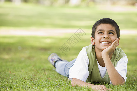年轻男孩户外躺在草地上微笑幸福孩子们水平年龄情感男性孩子闲暇和平阶段图片