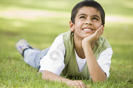 年轻男孩户外躺在草地上微笑焦距年龄和平情绪闲暇小学生孩子们水平阶段男性图片