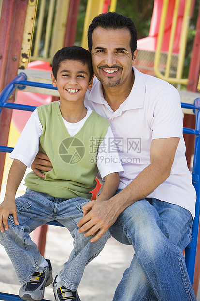 父亲和儿子坐在操场结构上笑着微笑情感情绪公园父亲们父母家长男性后代幸福男人图片