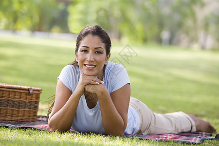 露着野餐篮子微笑躺在公园户外的妇女幸福焦距餐篮水平情感闲暇情绪成年人毯子女性图片