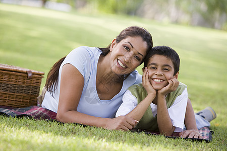 母亲和儿子在公园户外露着野餐微笑毯子焦距篮子情绪成年人餐垫餐篮幸福情感种族图片