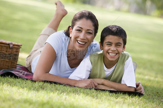 母亲和儿子在公园户外露着野餐微笑焦距女性餐垫餐篮幸福闲暇篮子情感种族成年人图片