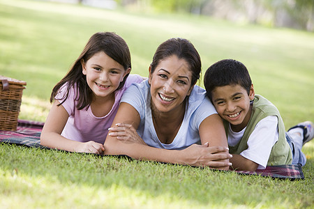 母亲和两个小孩在公园户外露着野餐微笑妈妈餐篮偏移角妈妈们闲暇水平孩子孩子们孕产后代图片