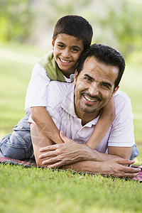父亲和儿子在户外公园里拥抱和微笑幸福男人父亲们中年爸爸后代情绪男士孩子们家庭图片