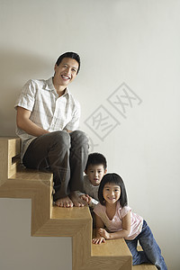 与儿童一起坐在楼梯上的男人图片