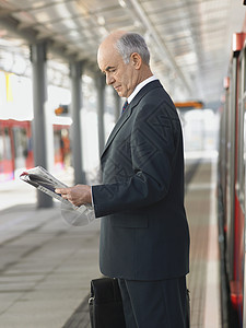 火车站的商务人士阅读报社图片