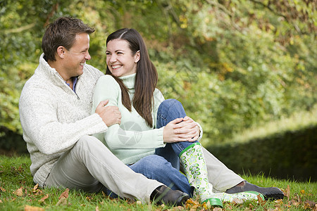 坐在户外的情侣拥抱和微笑家庭丈夫成年人身份父亲父亲们幸福爸爸们女儿人种图片