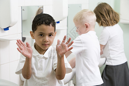 在洗手间用一根举着肥皂手的洗手池的学生选择性重点同学们浴室盆地男孩水槽浴室镜外表清洁度男孩们美容图片