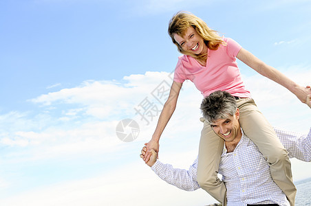 成熟的浪漫情侣女士活动肩膀幸福海滩妻子丈夫婴儿微笑男性图片