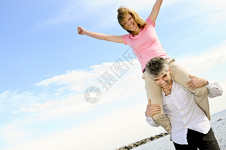 成熟的浪漫情侣微笑乐趣笑声妻子肩膀海滩婴儿女士男人幸福图片