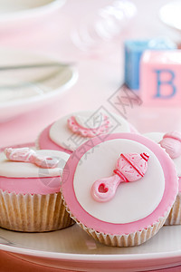 婴儿淋浴的蛋糕模块粉色建筑派对飘带软糖食物迎婴拨浪鼓积木背景图片