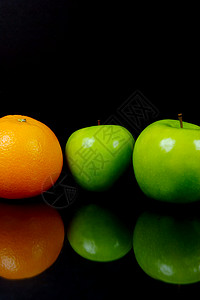 苹果和橙橘子水果黑色食物绿色背景图片