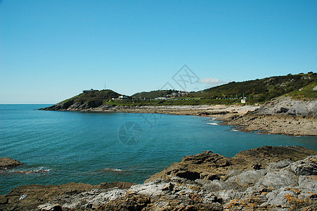 东海蓝色岩石爬坡石头悬崖天空海滩边缘绿色图片