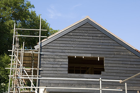 新房子天空脚手架房顶窗户乡村黑色蓝色建筑木头瓦片图片