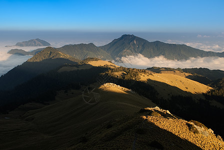 日落的美丽高山和金色草原蓝色环境地平线农村天空旅行晴天森林场地木头图片